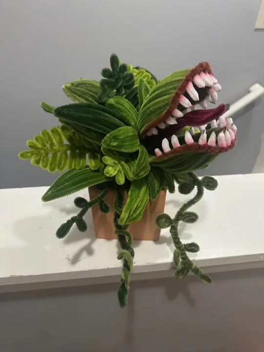 A wire Venus flytrap in a terracotta pot, jaws open