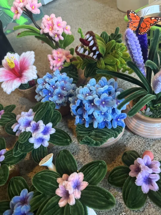 Blue and pink wire hydrangeas with a monarch butterfly, laid out among other flowers